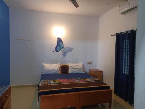a bedroom with a bed with butterflies on the wall at The Lungi Vibe in Varkala