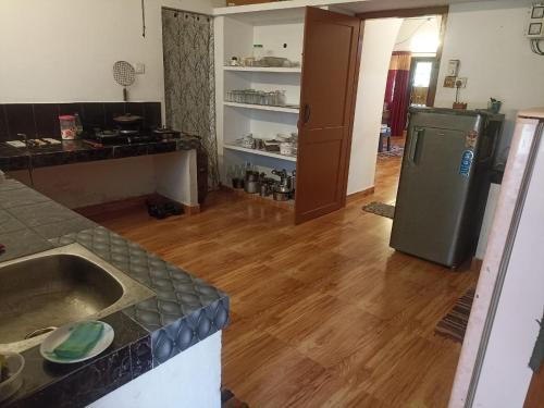 a kitchen with a sink and a refrigerator at The Lungi Vibe in Varkala