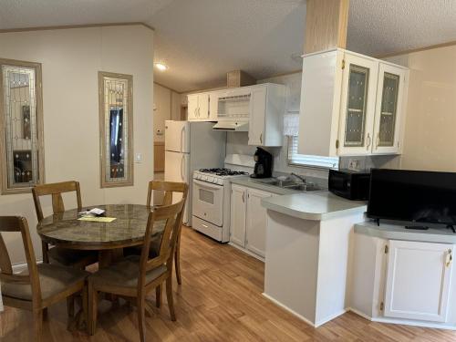 a kitchen with white cabinets and a table with chairs at Delightful 2 Bedroom Model Home in Pigeon Forge
