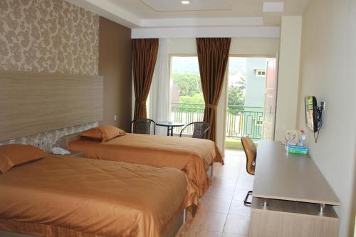 a hotel room with two beds and a balcony at Muara Hotel and Mall Ternate in Ternate