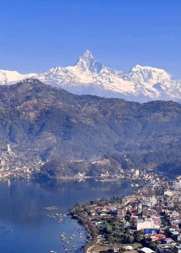 a view of a city and a lake with snow capped mountains at Sakar home stay in Pokhara