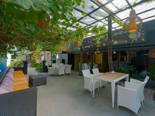 an outdoor patio with white chairs and tables at Bubu Homestay Tulamben in Tulamben