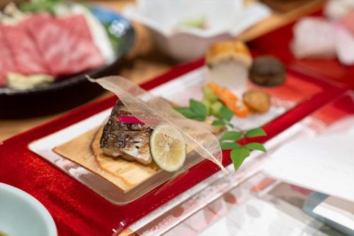 a red tray with a plate of food on a table at Dantokan Kikunoya in Otsu