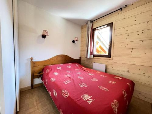 - une chambre avec un lit rouge dans une pièce avec une fenêtre dans l'établissement Les Chalets Des Evettes - Appartement deux chambres au pied des pistes dans une résidence avec piscine MAE-6291, à Flumet