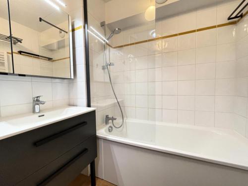 une salle de bain avec une baignoire, un lavabo et une douche dans l'établissement Les Chalets Des Evettes - Appartement deux chambres au pied des pistes dans une résidence avec piscine MAE-6291, à Flumet