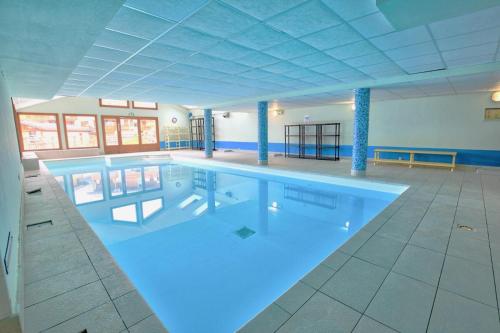 une grande piscine dans un grand bâtiment dans l'établissement Les Chalets Des Evettes - Appartement deux chambres au pied des pistes dans une résidence avec piscine MAE-6291, à Flumet