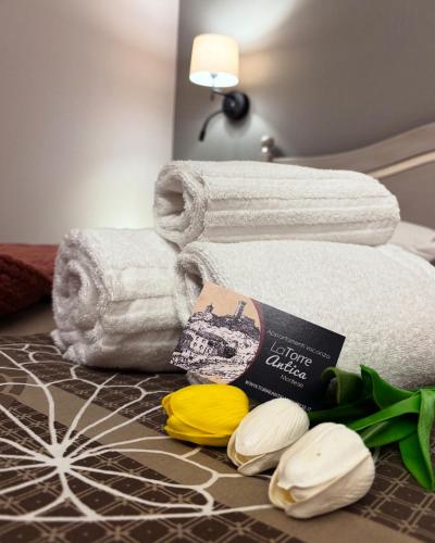 a pile of towels and flowers on a table at Torre Antica Montese appartamento 1 in Montese