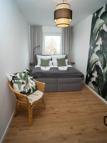 a bedroom with a bed and a chair and a window at MOREHOME Sonnenterrasse & Heimkino Switch 2 in Mindelheim