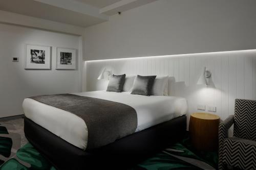 a bedroom with a large bed and a chair at The Ville Resort - Casino in Townsville