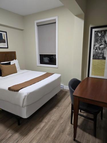 a bedroom with a bed and a desk and a table at Cozy Maison Apt #8 in Gatineau