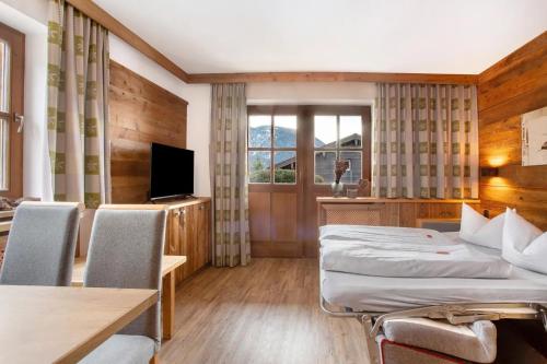 a hotel room with a bed and a television at Gästehaus Panorama - Appartement 1 in Reit im Winkl