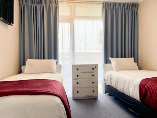 a bedroom with two beds and a window at Mount Eden Motel in Auckland