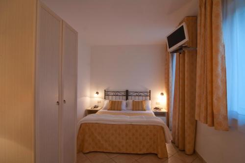 a bedroom with a bed and a tv on the wall at Hotel Sylesia in Letojanni