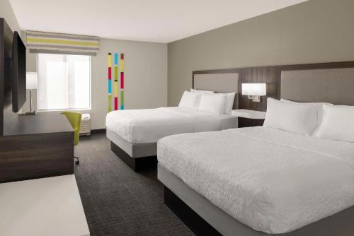 a hotel room with two beds and a window at Hampton Inn Olathe in Olathe