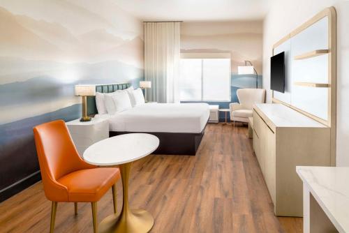 a hotel room with a bed and a table and a chair at DoubleTree by Hilton Phoenix-Gilbert in Gilbert