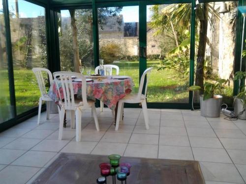 une table et des chaises assises sur un porche grillagé dans l'établissement Tremoyec, à Surzur