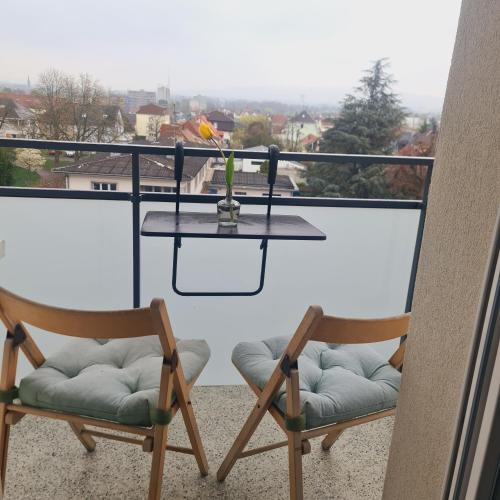 two chairs and a table on a balcony at Studio KULLA avec terasse 5mn Basel Airport in Saint-Louis