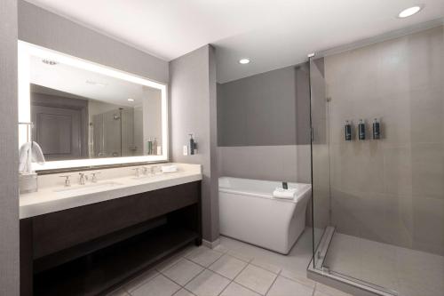 a bathroom with a sink and a shower and a toilet at Hilton Promenade Branson Landing in Branson