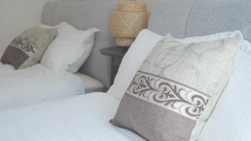 a bedroom with two beds with white sheets and a pillow at Villa Lotus in Kamakura