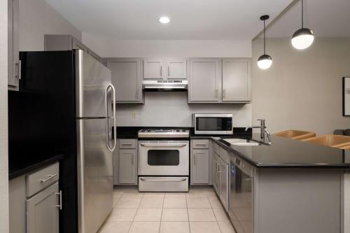 a kitchen with white cabinets and stainless steel appliances at Hilton Promenade Branson Landing in Branson