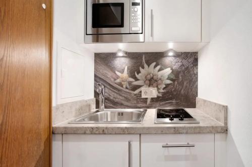 a kitchen with a sink and a microwave at Gästehaus Panorama - Appartement 4 in Reit im Winkl