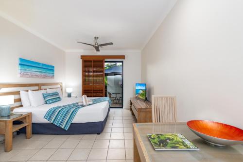 a bedroom with a bed and a dining room at Meridian at Port Douglas - Adults Only in Port Douglas