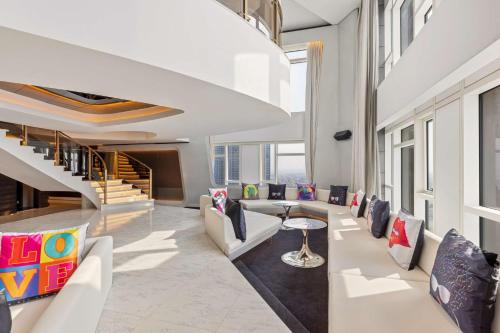 a living room with white furniture and a staircase at V Hotel Dubai, Curio Collection by Hilton in Dubai