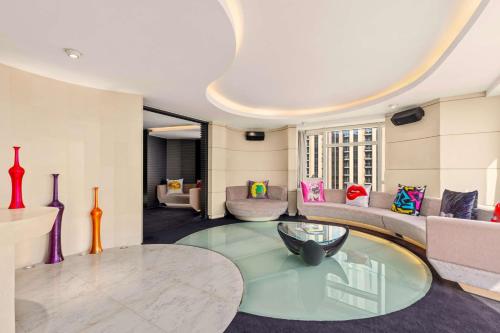 a living room with a table and a couch at V Hotel Dubai, Curio Collection by Hilton in Dubai