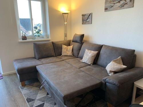 a living room with a brown couch with pillows at Ferienwohnung Iris, Kalifornien, Meerblick, erste Strandreihe in Schönberg