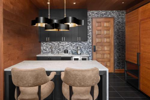 a kitchen with a counter and two chairs at Hotel Fraye Nashville, Curio Collection By Hilton in Nashville