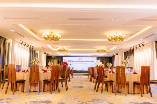 a conference room with tables and chairs and a projection screen at Green Dragon Boutique Hotel in Cẩm Phả