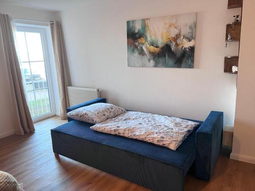a bedroom with a bed and a painting on the wall at Familienwohnung-Harbour-View in Orth