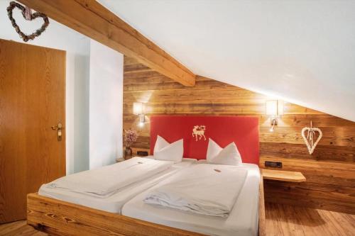 a bedroom with a large bed with a red headboard at Gästehaus Panorama - Appartement 7 in Reit im Winkl