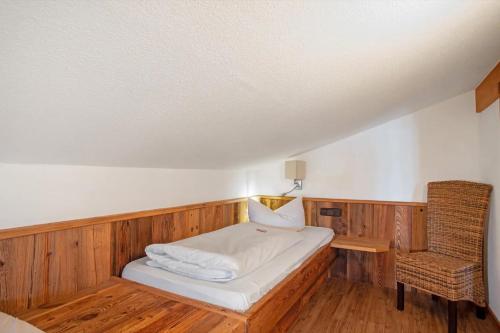 a small room with a bed and a chair at Gästehaus Panorama - Appartement 7 in Reit im Winkl