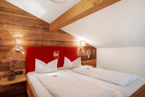 a bedroom with a large bed with a red headboard at Gästehaus Panorama - Appartement 7 in Reit im Winkl