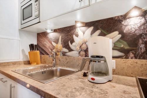 a kitchen with a mixer on a counter next to a sink at Gästehaus Panorama - Appartement 7 in Reit im Winkl