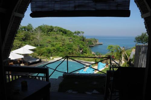 a view of a swimming pool and the ocean at Milo's Home in Jimbaran