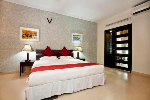 um quarto grande com uma cama grande e almofadas vermelhas em Well Park Residence Boutique Hotel & Suites em Chittagong