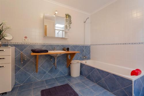 y baño con lavabo, bañera y mesa. en El refugio, en La Oliva
