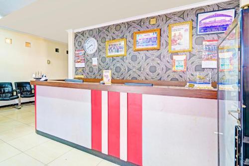 a restaurant counter with a red and white striped wall at Hotel O Pasteur Near Nuart Sculpture Park Formerly Maleo Exclusive in Bandung