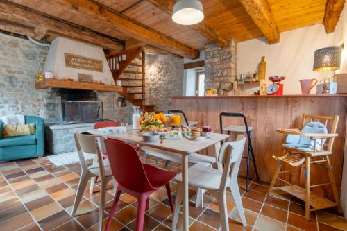 a kitchen and dining room with a table and chairs at Maison de village au cœur des remparts in Sainte-Eulalie-du-Cernon