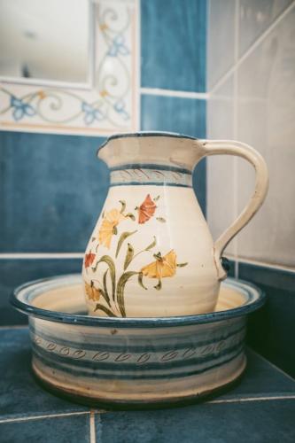 un vase assis au-dessus d'un comptoir dans l'établissement Maison de village au cœur des remparts, à Sainte-Eulalie-de-Cernon