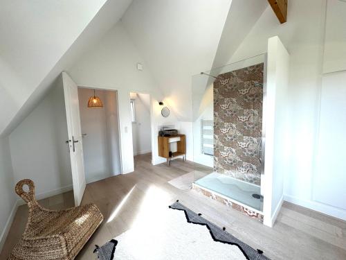 - un salon avec une chaise et une cheminée dans l'établissement La Villa Bretonniere - Piscine & SPA - 9p, à Notre-Dame-de-Courson