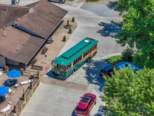 a green bus parked in a parking lot with cars at 2BR Retreat with Stunning Mountain Views in Pigeon Forge
