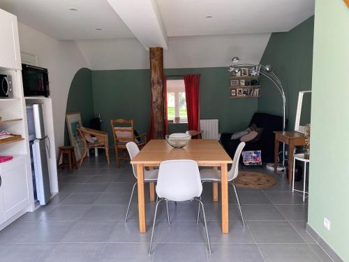 une salle à manger avec une table et des chaises blanches dans l'établissement La petite maison de la ferme d'Armentières, à Saint-Benoist-sur-Vanne