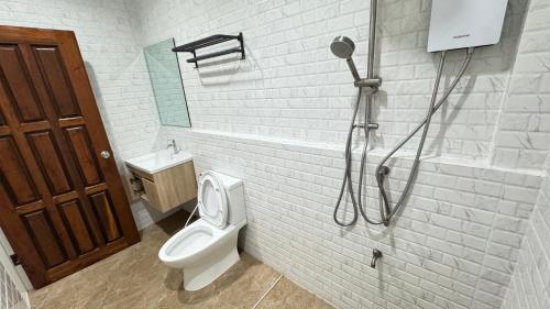 a white bathroom with a toilet and a shower at Aekarak เอกลักษณ์ in Ban Chom Chaeng