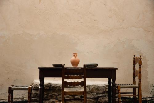 a table with a vase sitting on top of it at Krasospito 1850 - a Corfiot Wine House Reborn in Lefkimmi