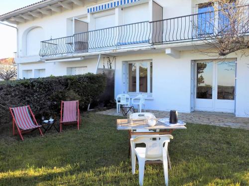 une table et des chaises devant une maison dans l'établissement Royan - Plage du Chay - APPARTEMENT en REZ-DE-JARDIN avec APERCU MER, à Royan