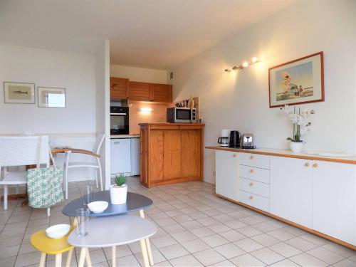 - une cuisine avec une petite table et un comptoir dans l'établissement Royan - Plage du Chay - APPARTEMENT en REZ-DE-JARDIN avec APERCU MER, à Royan