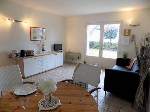 un salon avec une table et une cuisine dans l'établissement Royan - Plage du Chay - APPARTEMENT en REZ-DE-JARDIN avec APERCU MER, à Royan